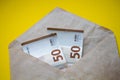 Euro banknotes in white envelope. Open envelope with money banknotes on table. White envelope with Euro money bills. Closeup on En