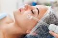Receiving electric darsonval facial massage procedure at beauty salon. Royalty Free Stock Photo