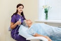 Receiving electric darsonval facial massage procedure at beauty salon. Royalty Free Stock Photo