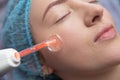 Receiving electric darsonval facial massage procedure at salon Royalty Free Stock Photo