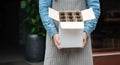 Barman in apron holds open box with bottles of beer