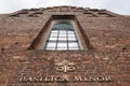 The Basilica Minor sign on the red bricks wall at the entrance to the church