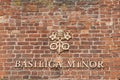 The Basilica Minor sign on the red bricks wall at the entrance to the church