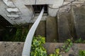 Recently flooded basement seen with a large pipe used to pump out flooded basement water.