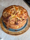 Homemade apple, raisin and cranberry pie, on round wooden board