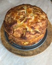 Homemade apple, raisin and cranberry pie, on round wooden board