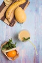 Recepie of healthy fresh yellow fruit mango smoothie at blue table