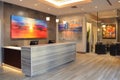 Reception area with a sleek desk and contemporary painting on the wall, A reception area with a sleek desk and modern artwork on