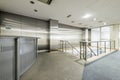 Reception desk of Spacious empty coworking office with gray stainless steel walls and stairs with metal railings