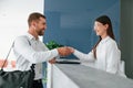 At reception. Man in white shirt is ordering a room in the hotel by woman\'s help Royalty Free Stock Photo