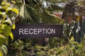 A reception sign in the garden of the hotel entry