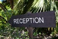A reception sign in the garden of the hotel entry