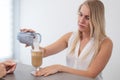 Receptionist in a beauty salon prepares coffee for a client.