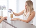 Receptionist in a beauty salon prepares coffee for a client.