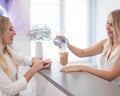 Receptionist in a beauty salon prepares coffee for a client.