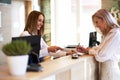 Receptionist and businesswoman at hotel front desk Royalty Free Stock Photo