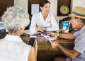 Receptionist giving explanations to a senior man Royalty Free Stock Photo