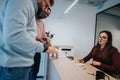 Professional receptionist assisting guests with reservation and check-in process at hotel. Royalty Free Stock Photo