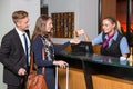 receptionist at hotel reception handing over key to guest or customer Royalty Free Stock Photo