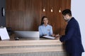 Receptionist registering client at desk