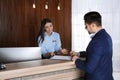 Receptionist registering client at desk