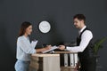 Receptionist registering client at desk