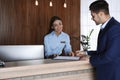 Receptionist registering client at desk