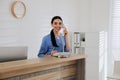 Receptionist talking on phone at countertop Royalty Free Stock Photo