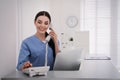 Receptionist talking on phone at countertop in hospital Royalty Free Stock Photo