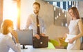 Receptionist talking to manager on telephone while business people standing and waiting in office lobby Royalty Free Stock Photo