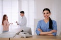 Receptionist working at countertop while talking with patient Royalty Free Stock Photo