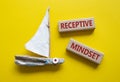 Receptive Mindset symbol. Concept word Receptive Mindset on wooden blocks. Beautiful yellow background with boat. Business and