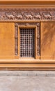 Wooden grid window in ornamental wall outside of old stone building