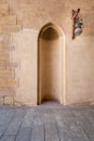 Recessed frame, niche and glass street lantern hanged on a wooden pole in an old stone bricks wall Royalty Free Stock Photo