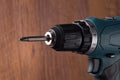 Rechargeable electric screwdriver on wooden background. Repair and handicraft