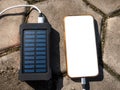 Rechargeable mobile power pack with solar panels, close-up. Connected to and charging a mobile, tablet or smart phone Royalty Free Stock Photo