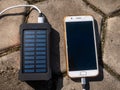 Rechargeable mobile power pack with solar panels, close-up. Connected to and charging a mobile, tablet or smart phone Royalty Free Stock Photo