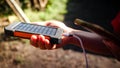 A rechargeable mobile power pack with solar panels in young female traveler`s hands, close-up. Connected to and charging a mobile Royalty Free Stock Photo