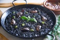 Black rice paella with seafood and fish. Traditional Spanish recipe. Royalty Free Stock Photo