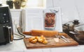 Recipe book open showing instructions to make roast chicken on a kitchen worktop