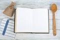 Recipe cook blank book on wooden background, spoon, rolling pin, checkered tablecloth. Top view