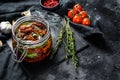 Recipe for cooking dried tomatoes in olive oil with spices and herbs. Black background. Top view. Copy space Royalty Free Stock Photo