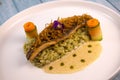 Recipe for fried fillet of sea bass with herb risotto, white wine sauce, fresch creme, roll of carrot and courgette