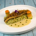 Recipe for fried fillet of sea bass with herb risotto, white wine sauce, fresch creme, roll of carrot and courgette