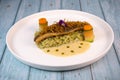 Recipe for fried fillet of sea bass with herb risotto, white wine sauce, fresch creme, roll of carrot and courgette