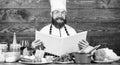 This recipe is just perfect. Man bearded hipster read book recipe near table fresh vegetables. Culinary arts. Recipe to Royalty Free Stock Photo