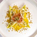 Recipe for salmon gravlax salad, endives filled with creame fresh, chives, yellow chioggia beetroot and leek shoots