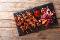 Recipe of a spicy African suya kebab on skewers with fresh vegetable salad and ketchup close-up. Horizontal top view Royalty Free Stock Photo