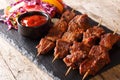 Recipe of a spicy African suya kebab on skewers with fresh vegetable salad and ketchup close-up. horizontal Royalty Free Stock Photo