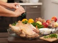A woman sprinkles salt on the Turkey for roasting Royalty Free Stock Photo